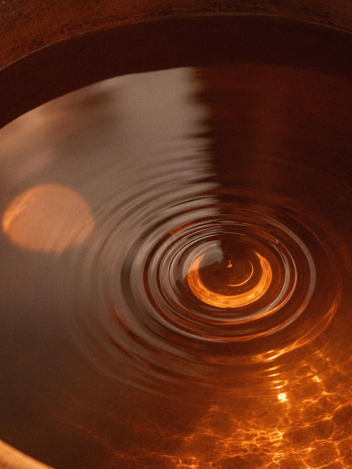 Ripples across warm water in a clay bowl